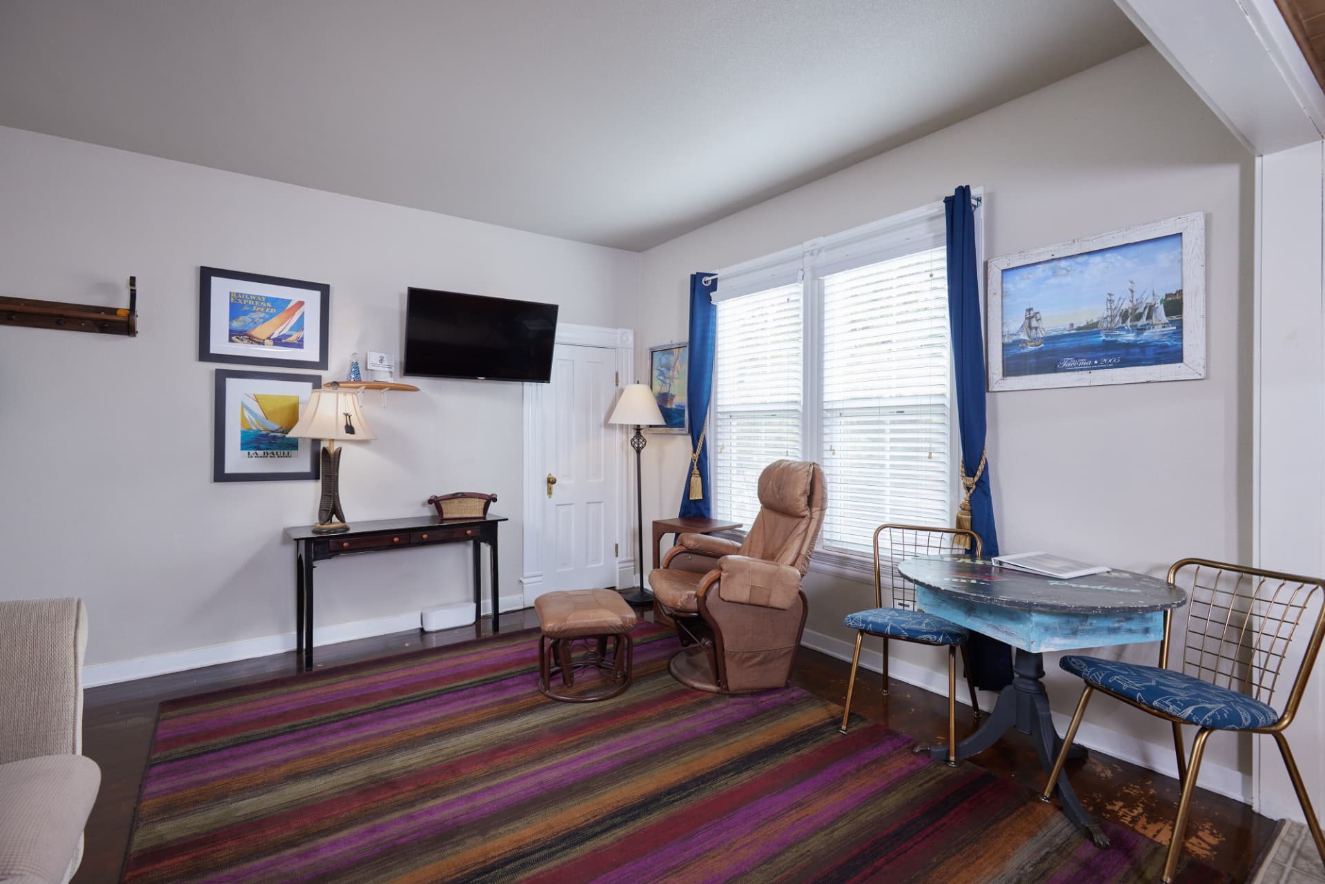 Wide view of The Harbor living room with recliner and blue curtains