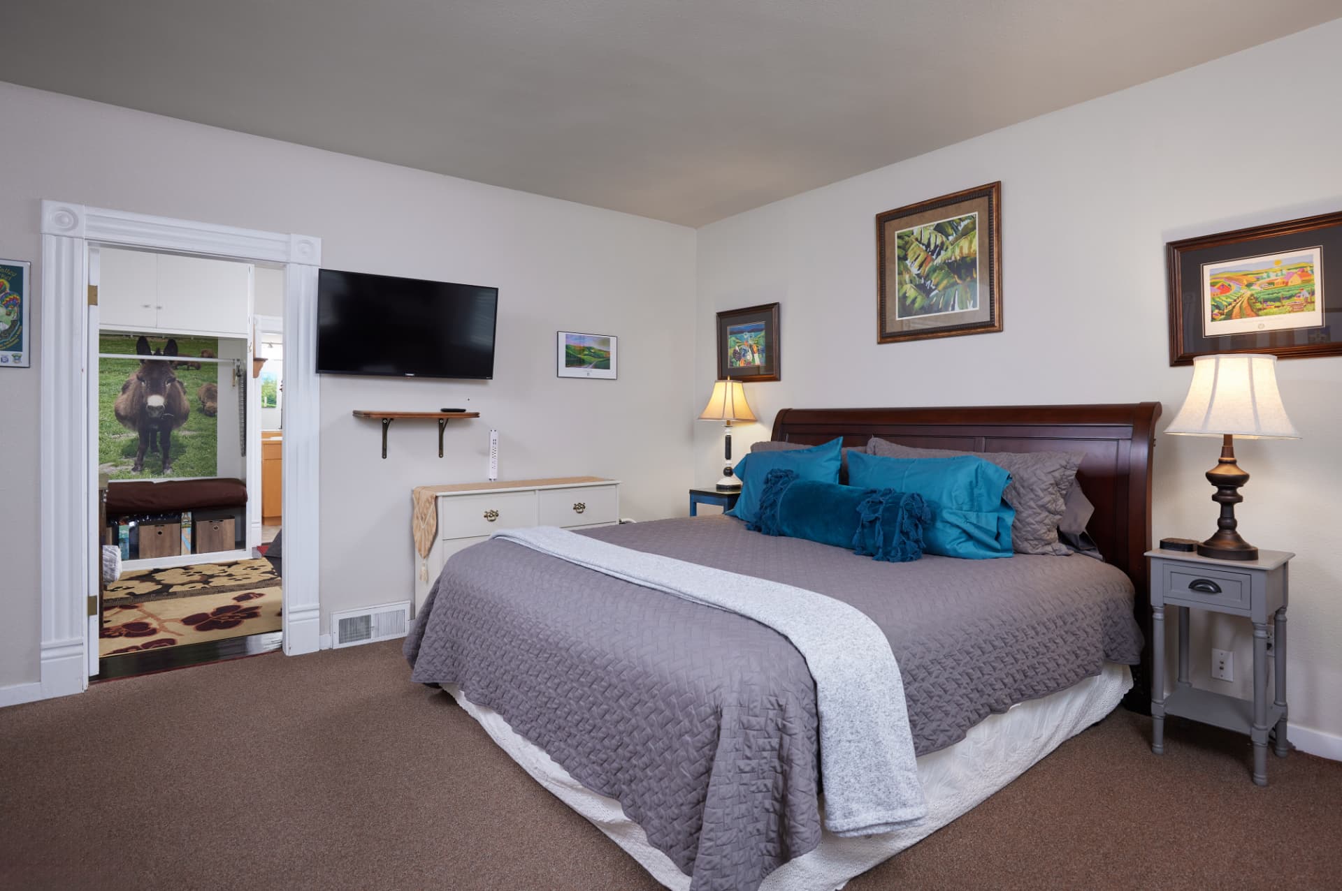 The Vineyard bedroom with smart TV, white dresser and door to the second bedroom