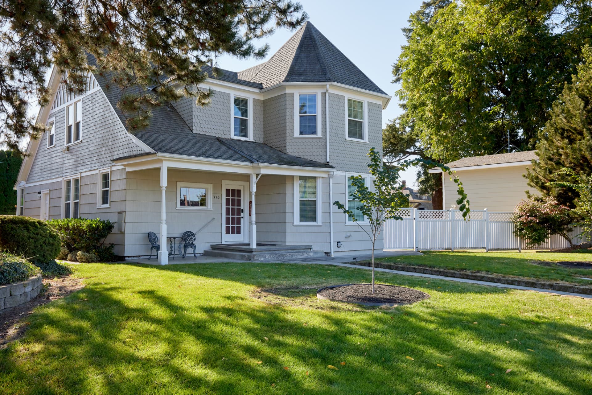 Side view of the Poplar Places house with a wide lawn and shade trees