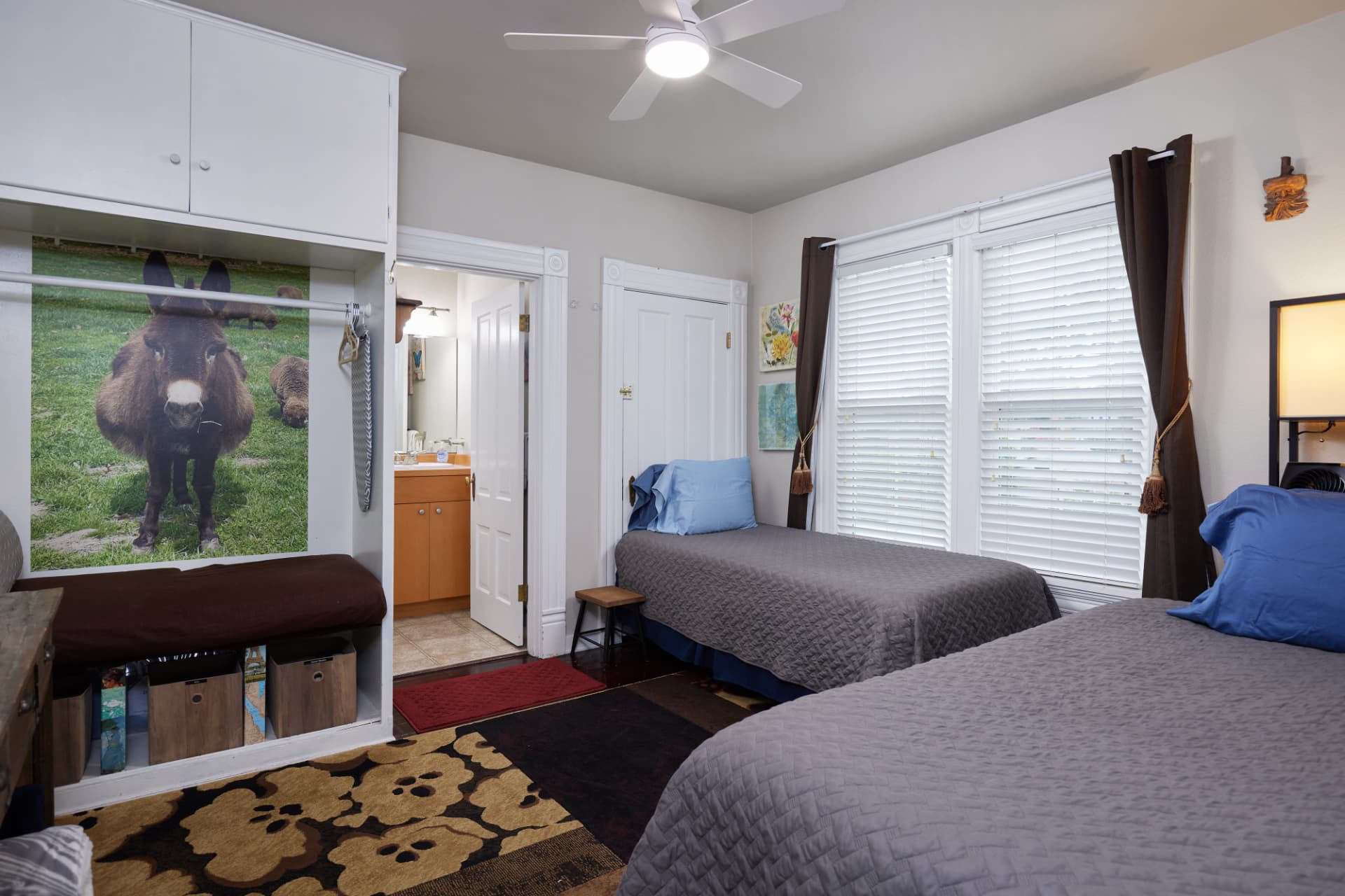 The Vineyard second bedroom with two twin beds and a painted donkey mural