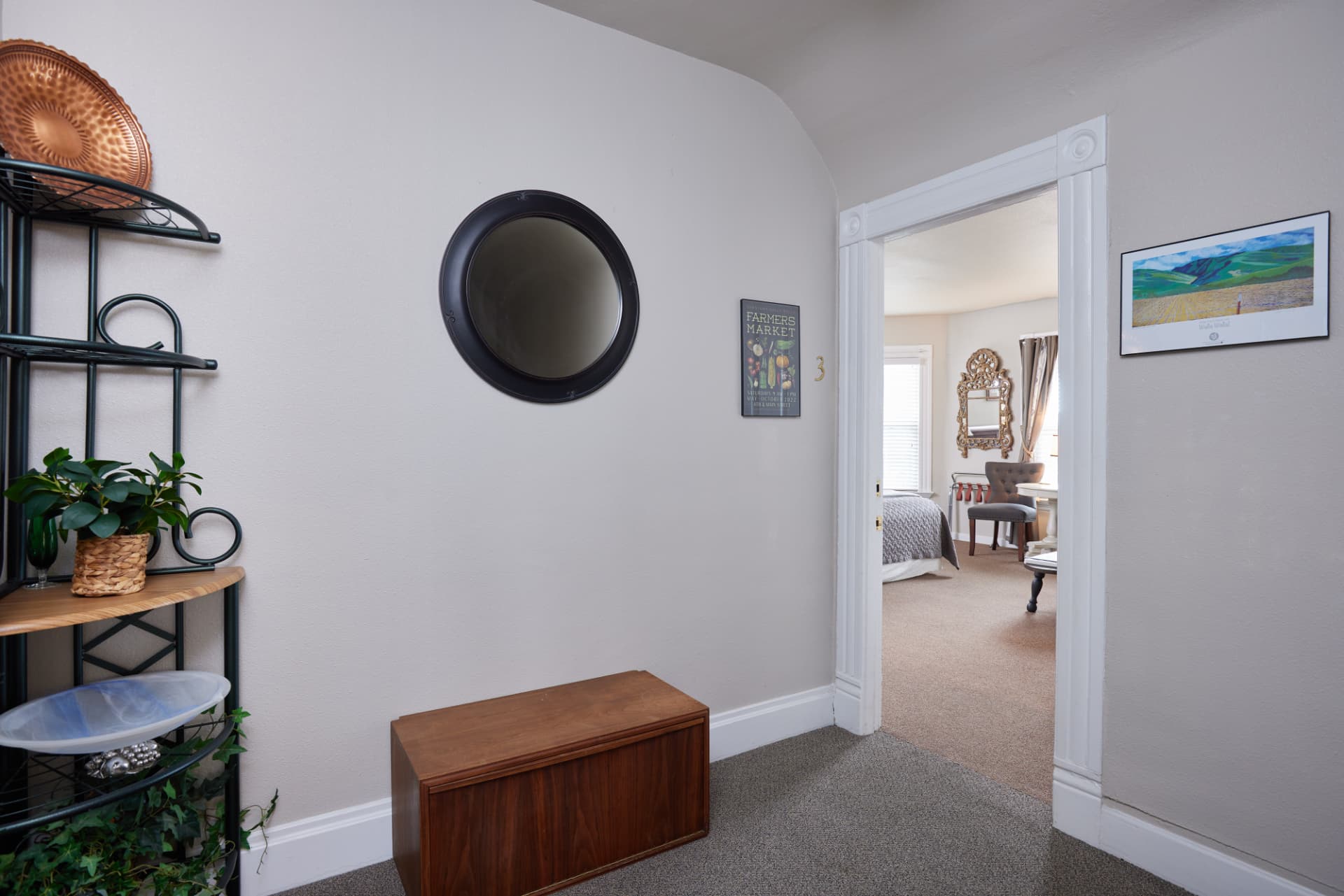 The Vineyard entry with a round black mirror and farmers market poster