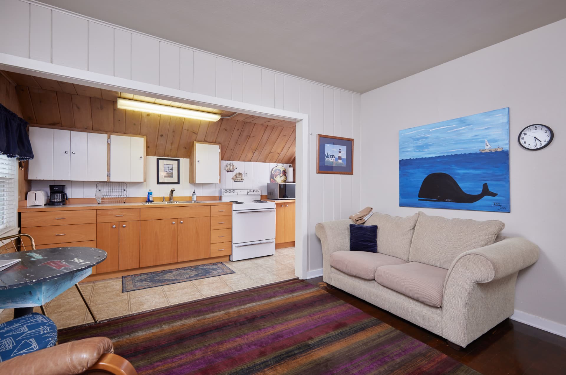 The Harbor living area with a cream sofa and a large whale painting